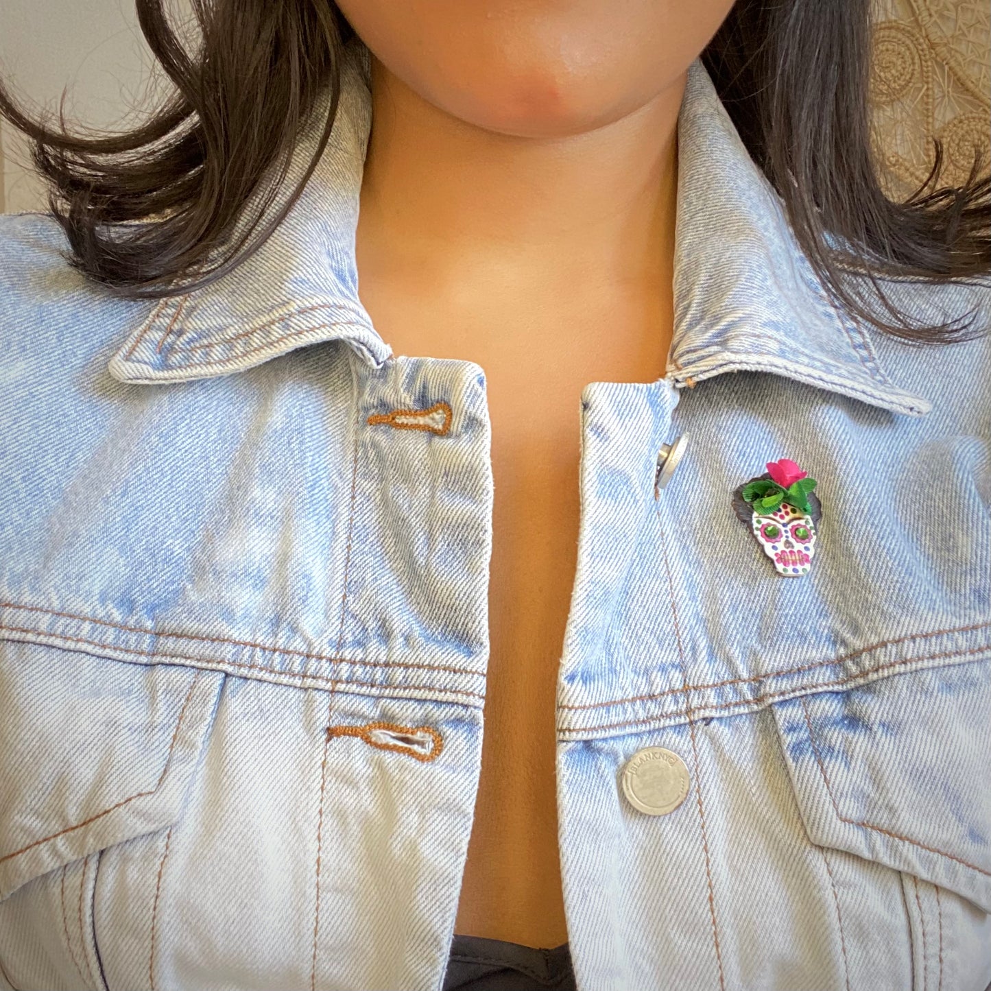 Day of the dead brooch on model wearing a jean jacket. Handmade in Colombia.