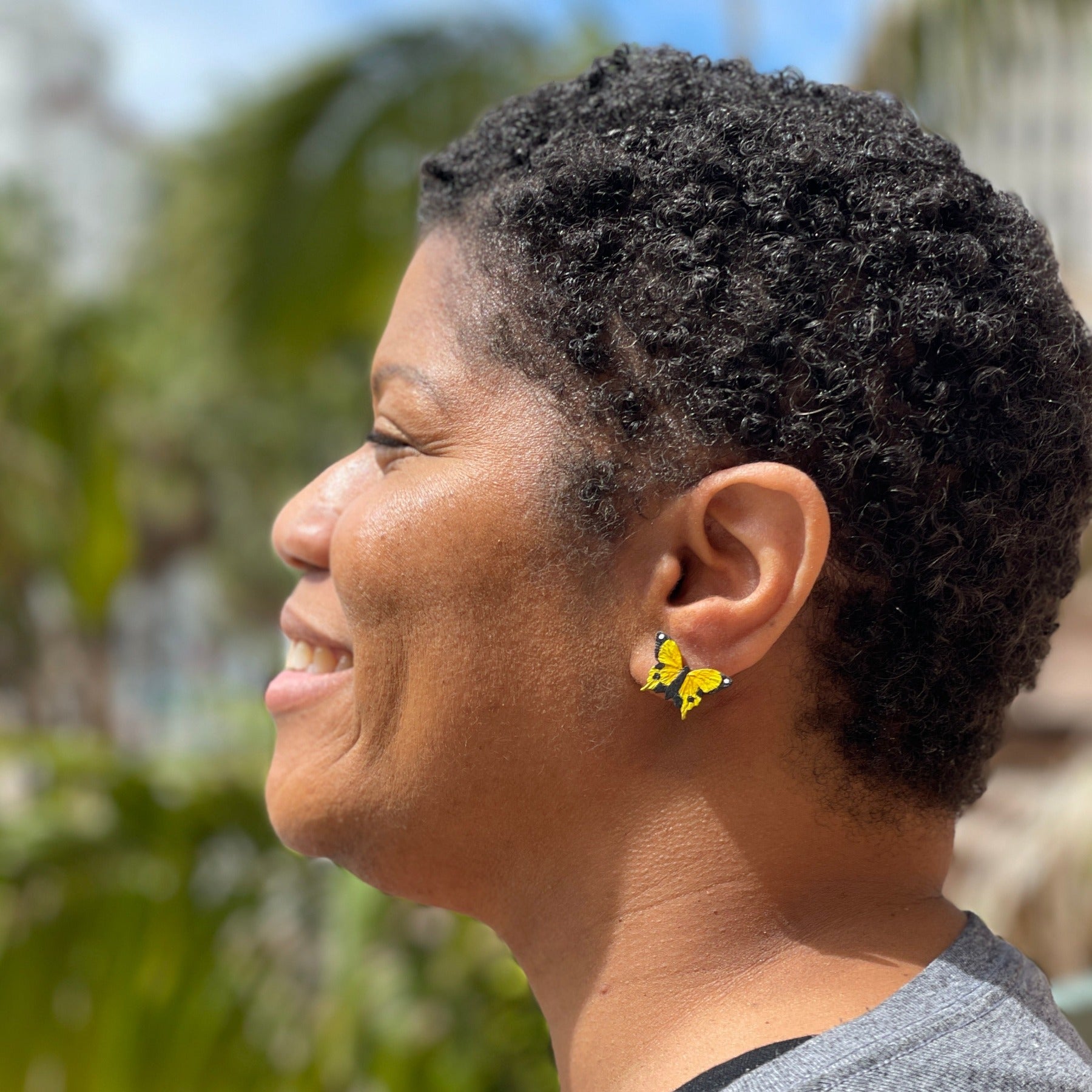 Model wearing yellow butterfly earring studs