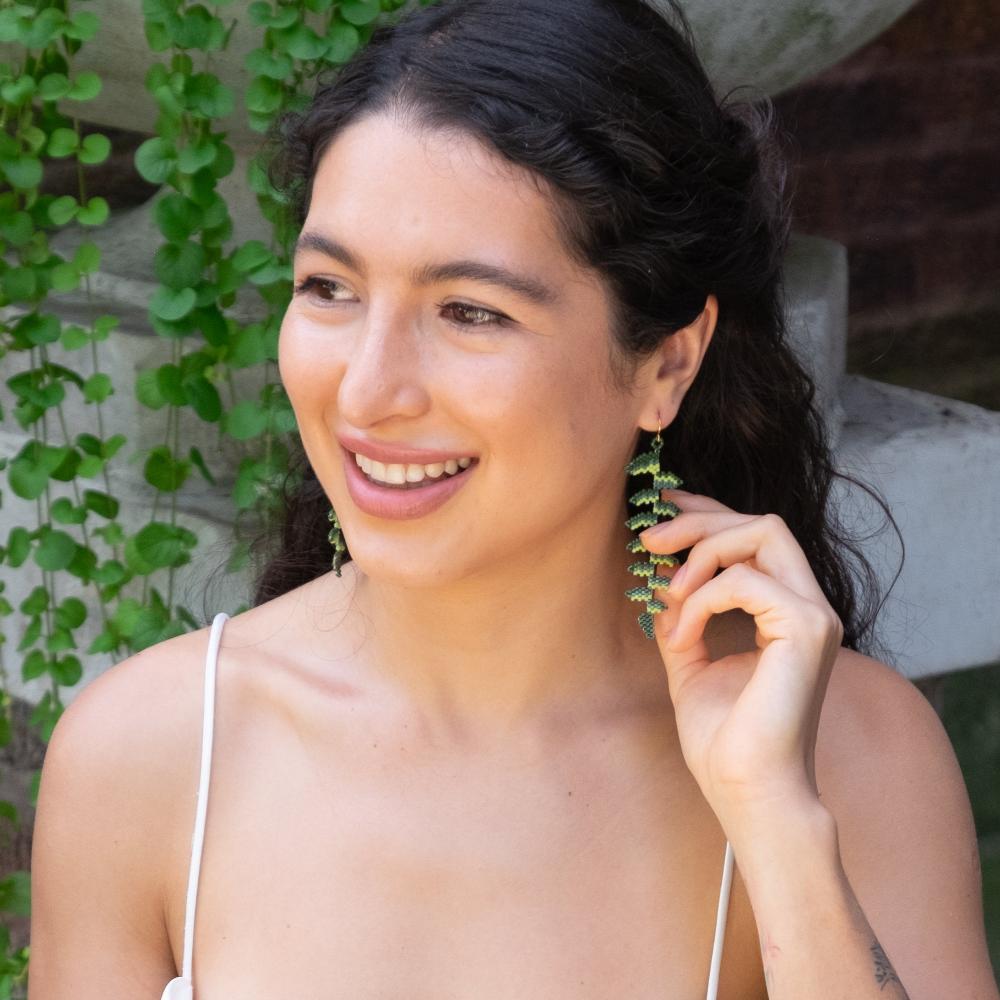 Colombian model wearing glass beaded fern earrings. 