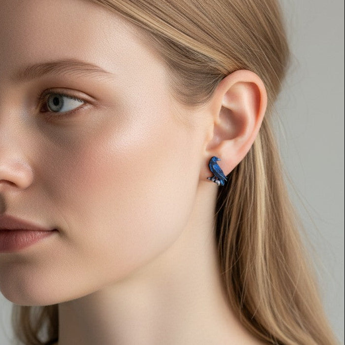 Close-up of a woman wearing a blue earring against a neutral background