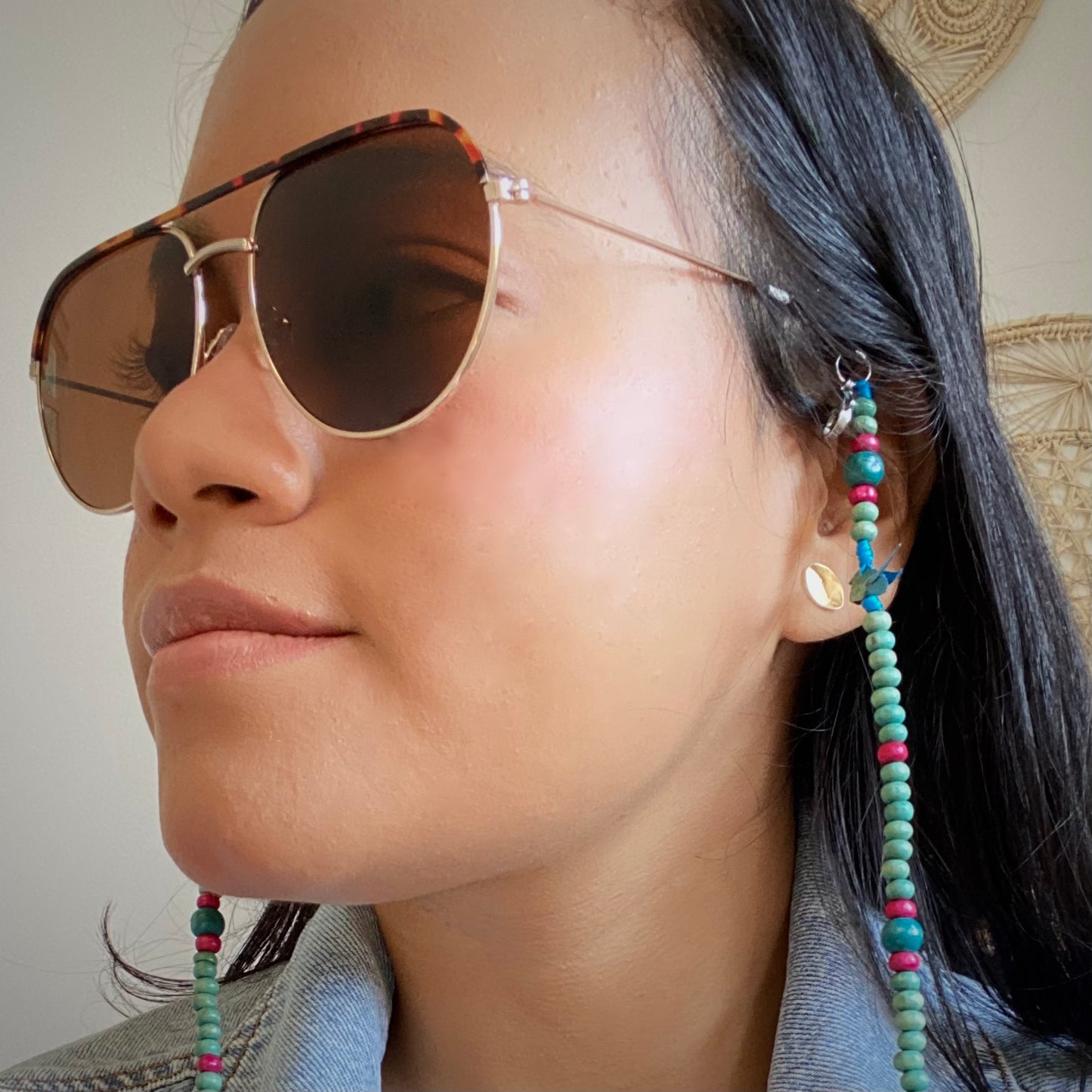 Model wearing sunglasses with blue bird chain.  Handmade in Colombia.