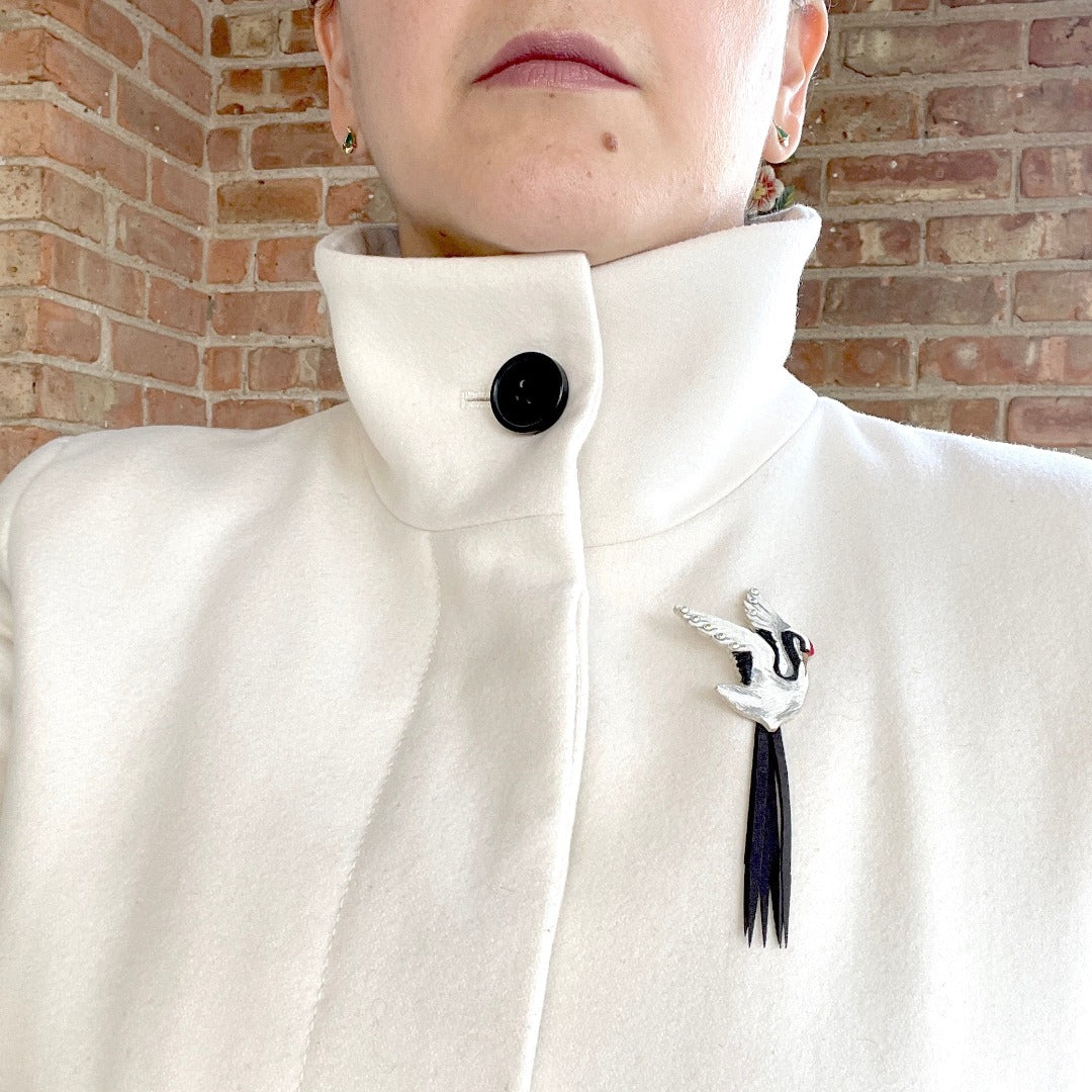 Crane Brooch on model wearing white coat.