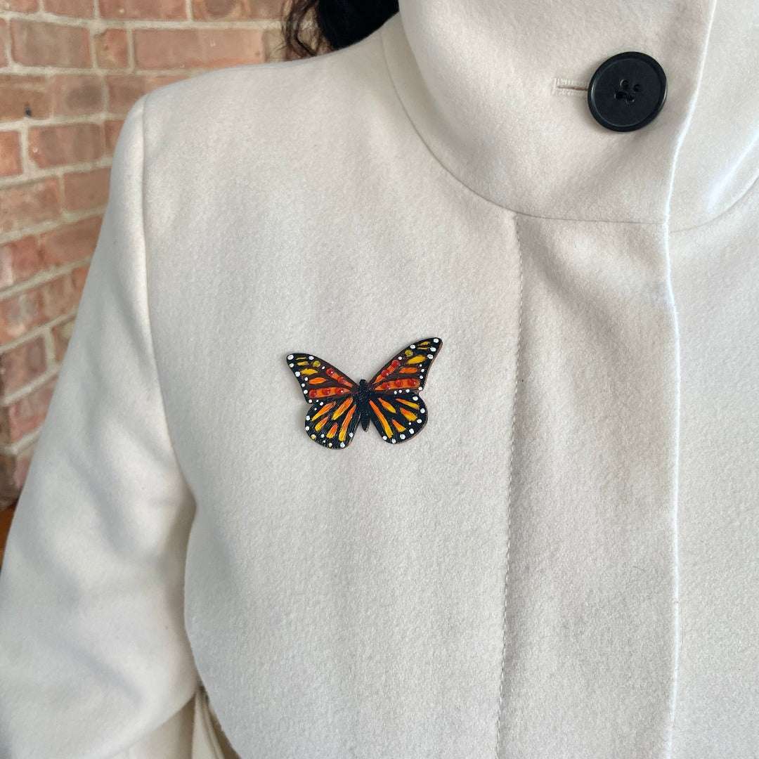 Monarch Brooch on model wearing a white coat.