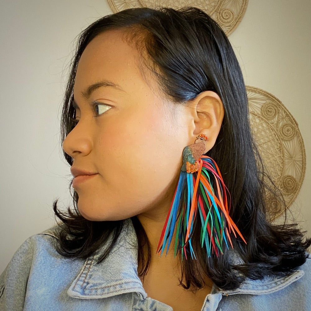 Model wearing XL Rooster earrings. Handmade in Colombia. Tulia's Artisan gallery. 