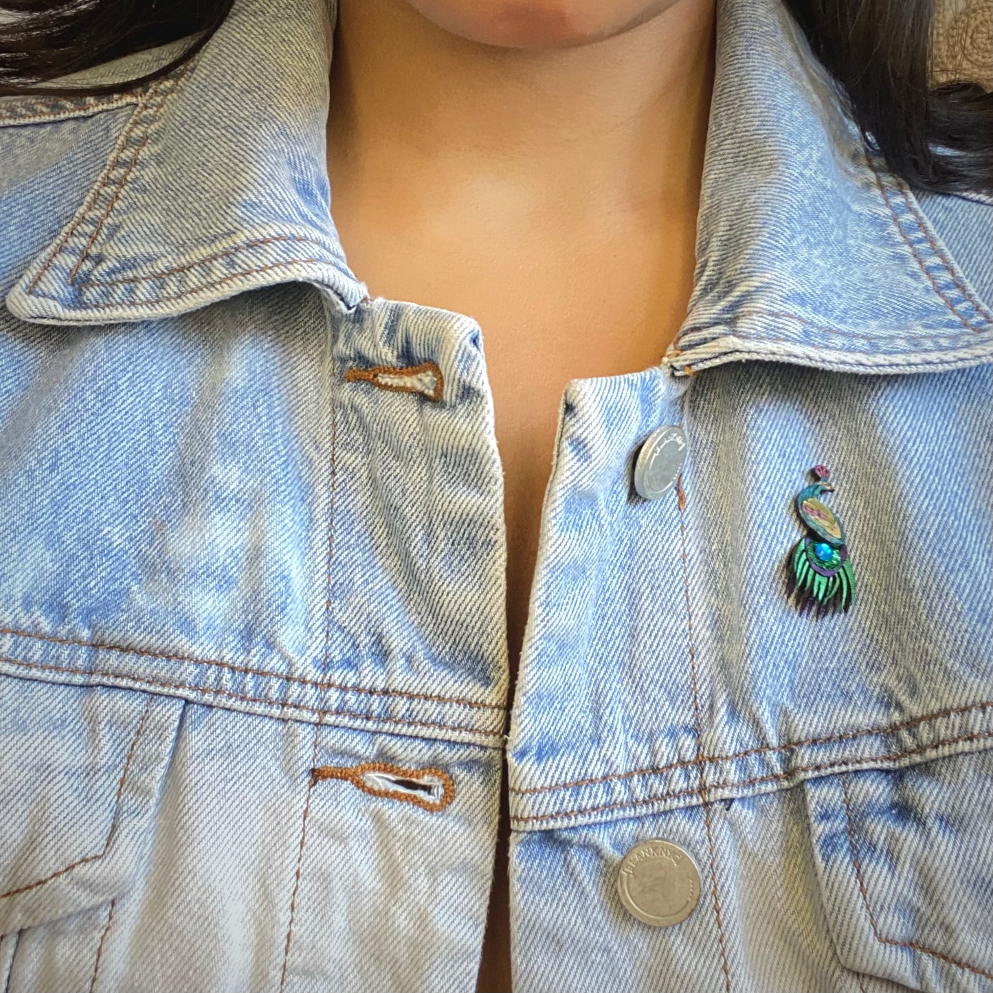 XS Peacock brooch pin on model wearing a jean jacket.  Handmade in Colombia. 